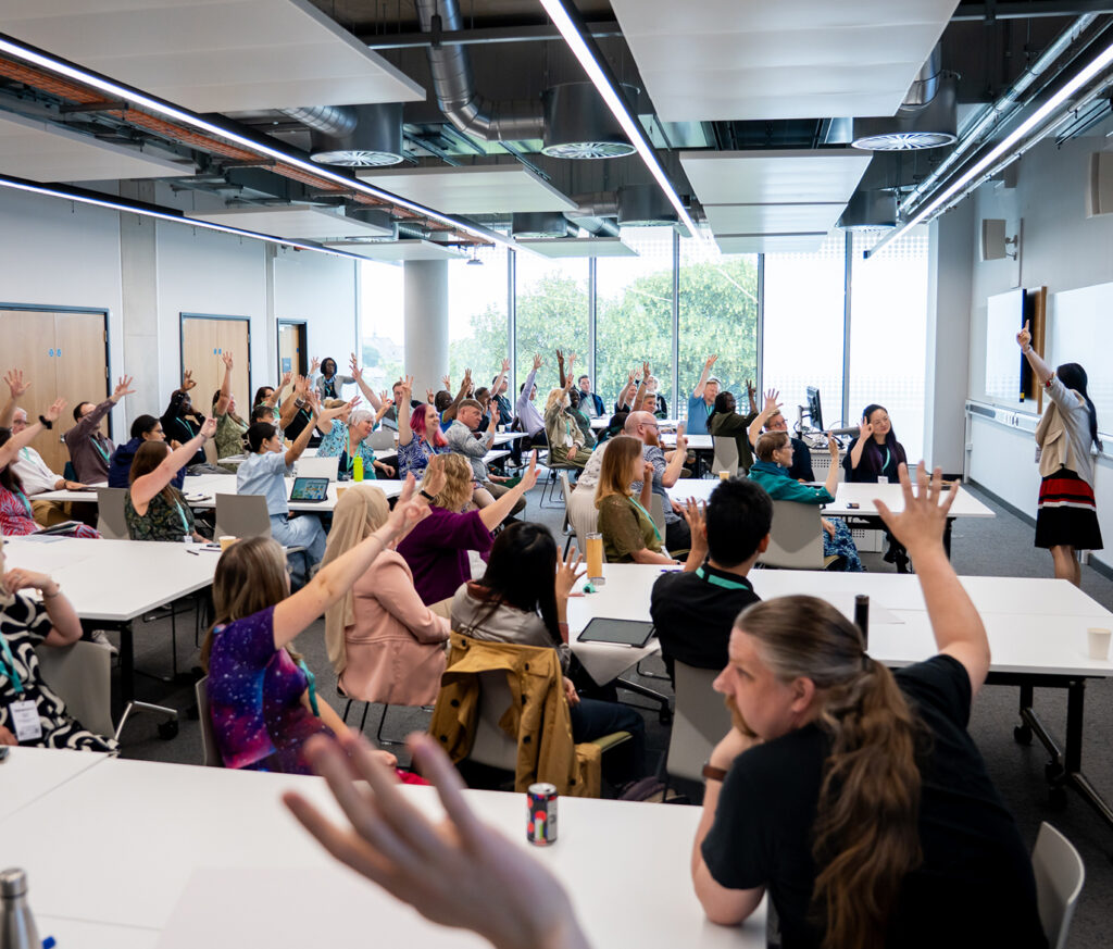 Conference workshop where everybody has their hands up