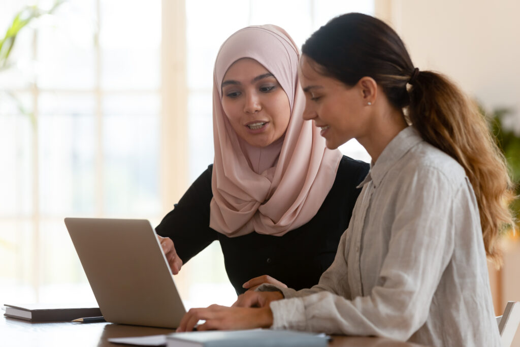 Two people working on a laptop