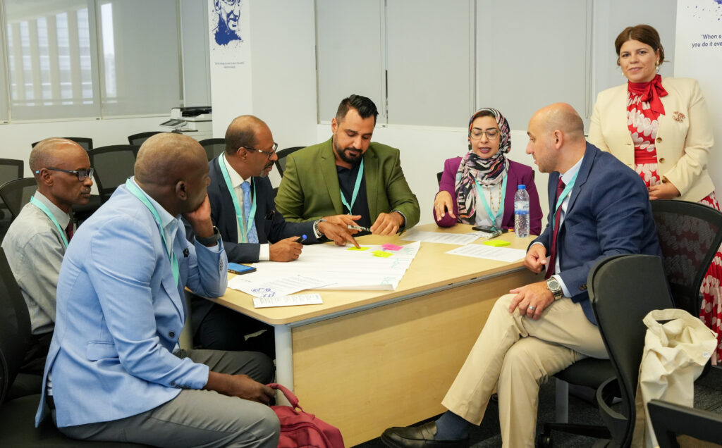 a group of people working together at a table.