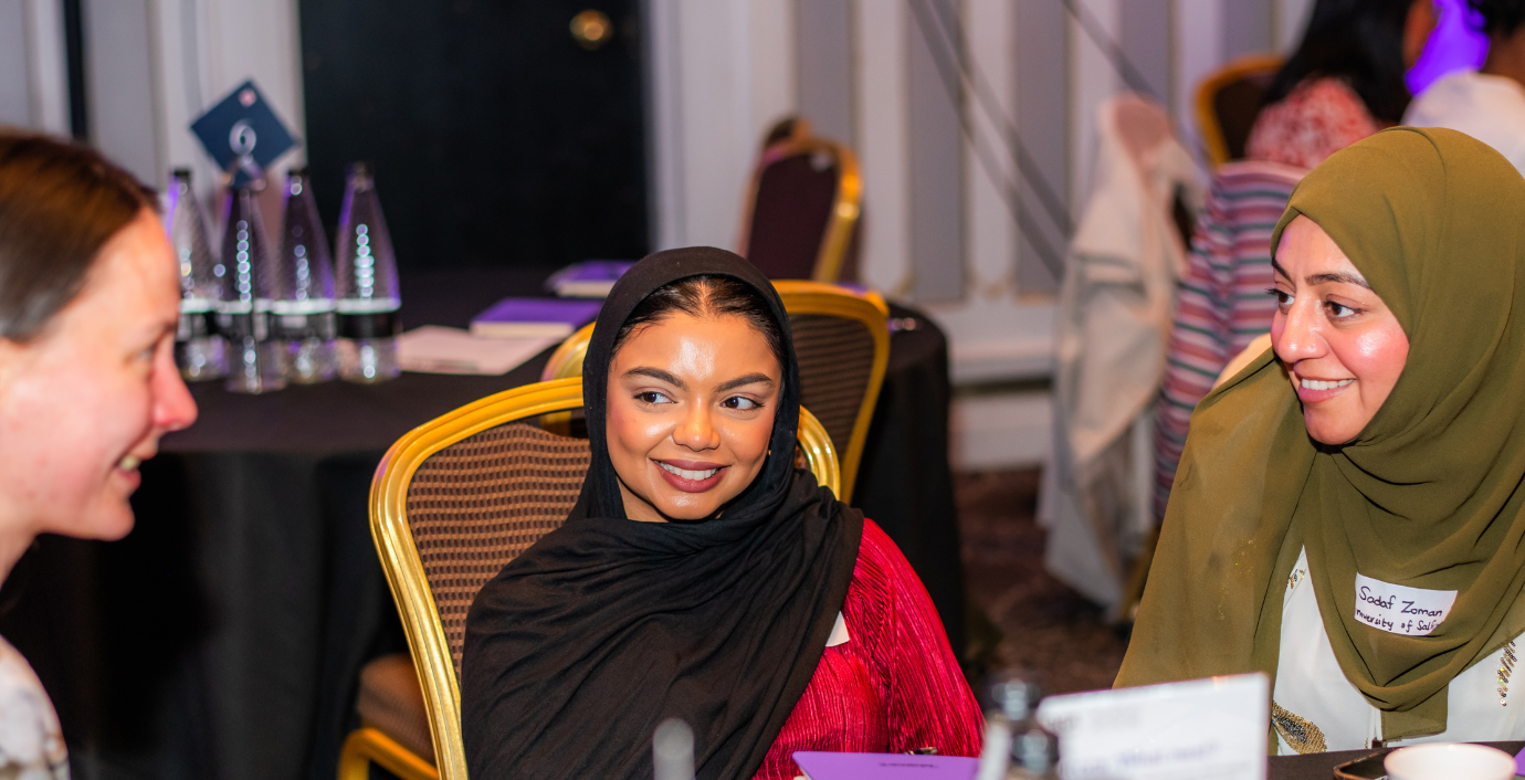Three women in conversation around a table