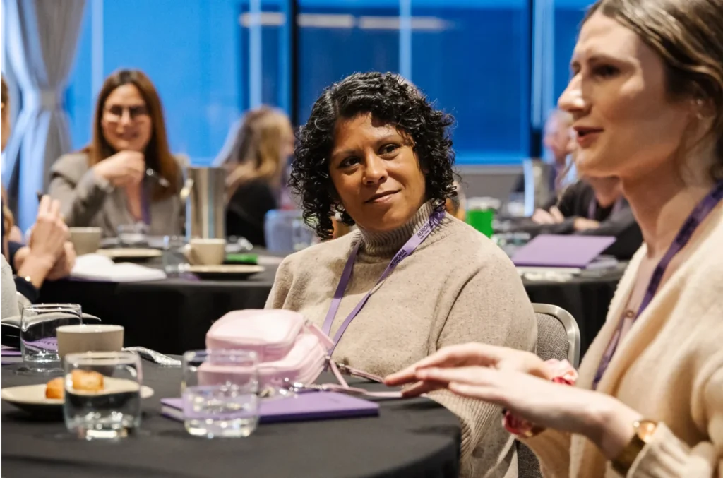 a person listening to another person participating at a conference