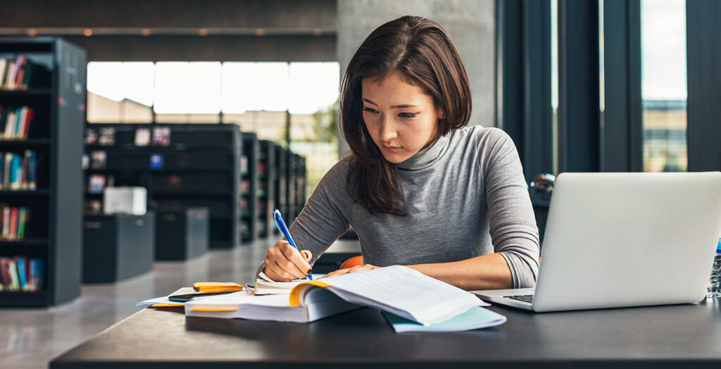 woman studying at a library table