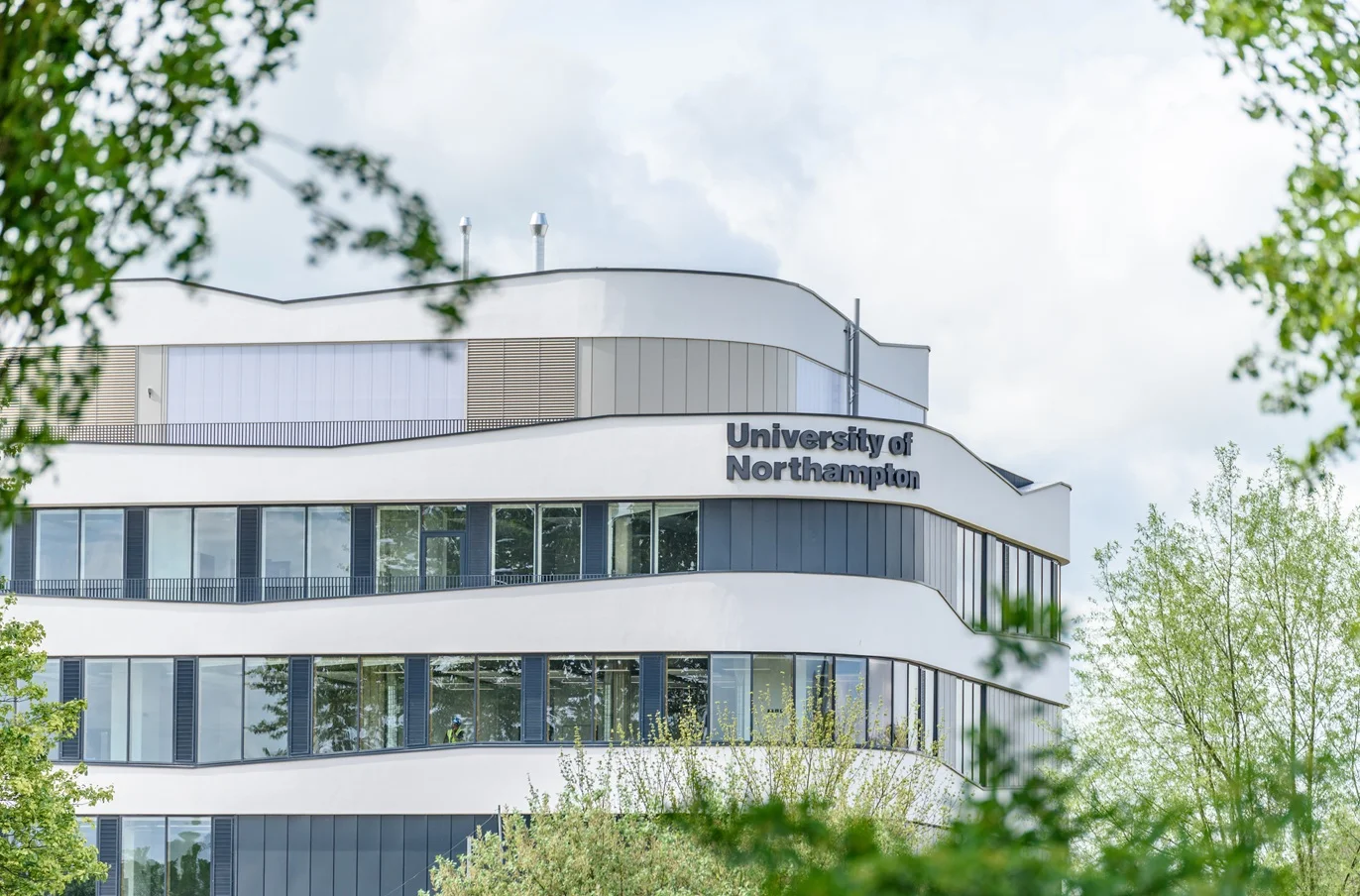 University of Northampton logo sign on new building on Nene river